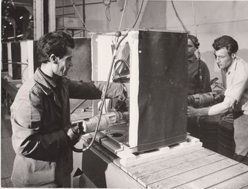 Screwing down the shock absorber on a washing machine from the front and rear (Source: BSH Corporate Archives).