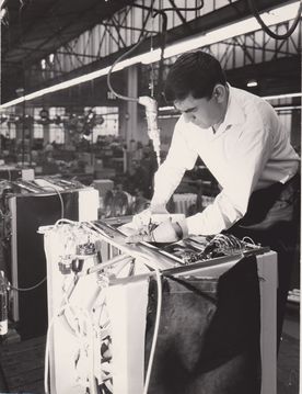 Installing a hose on a washing machine (Source: BSH Corporate Archives).
